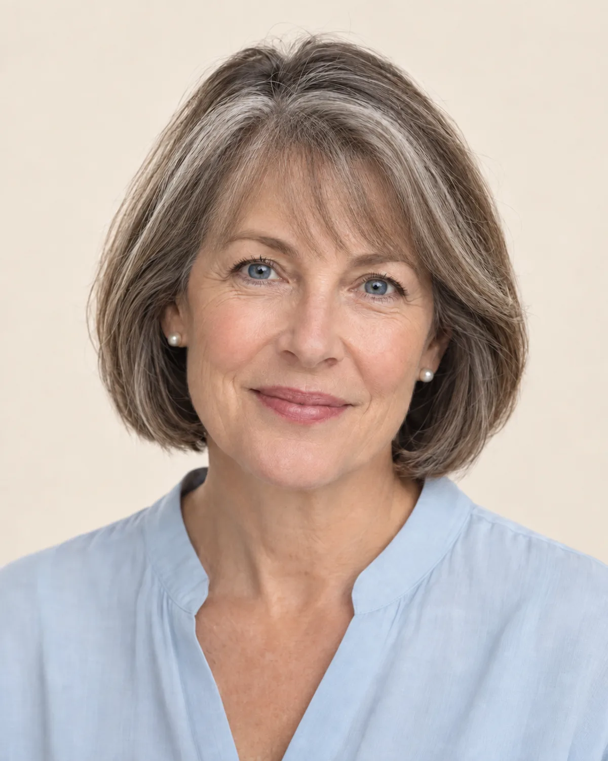 A woman with a gray-streaked bob and soft, wispy bangs.